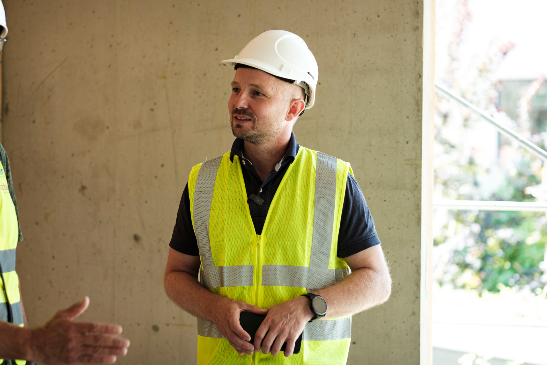 Marco Fehr mit Helm und Warnweste auf der Baustelle