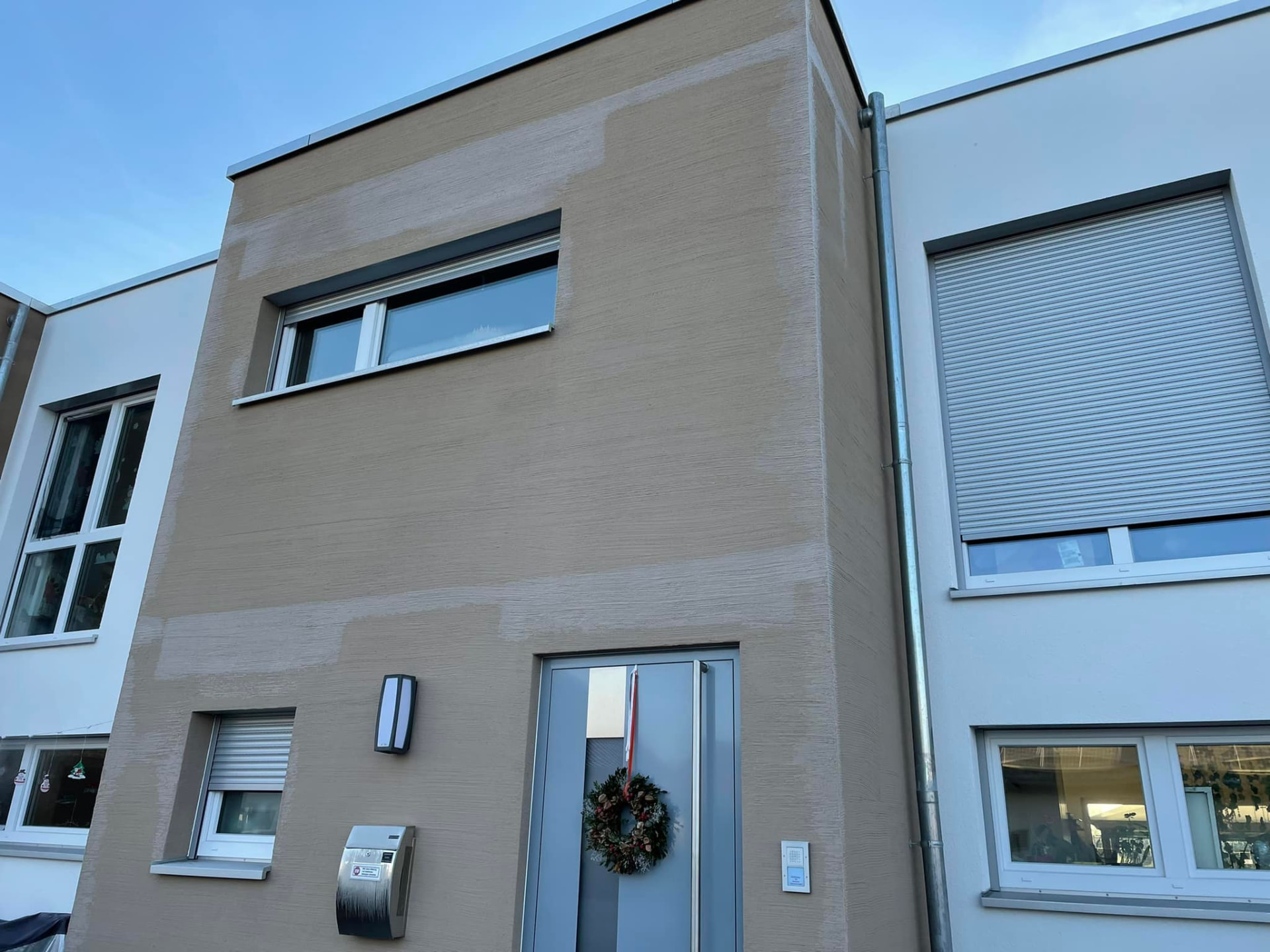 Fassade eines Reihenhauses mit sichtbaren Putzflickstellen